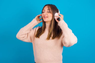 Kafasında kulaklıklarla örülmüş süveter giyen genç bir Arap kadın müzik dinliyor, gözlerinde kapalı gözlerle en sevdiği şarkıyı dinliyor, el ele tutuşuyor..