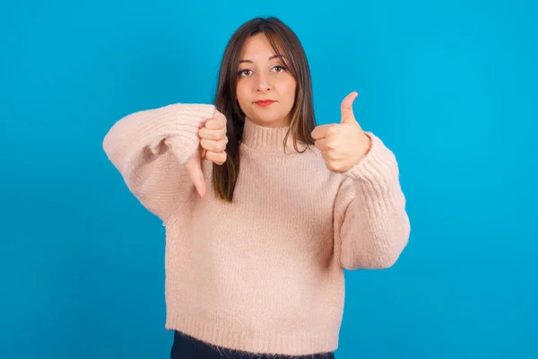 Mujer Árabe Joven Con Suéter Punto Sobre Backgtound Azul Mostrando —  Fotos de Stock