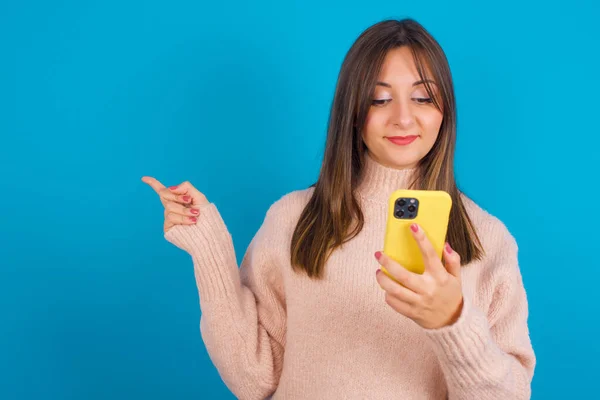 Sonriente Mujer Árabe Joven Con Suéter Punto Sobre Backgtound Azul —  Fotos de Stock