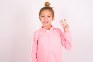 little caucasian kid girl wearing sport clothing over white background showing and pointing up with fingers number three while smiling confident and happy.