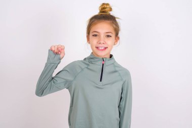 little caucasian kid girl wearing sport clothing over white background pointing up with fingers number ten in Chinese sign language Shi