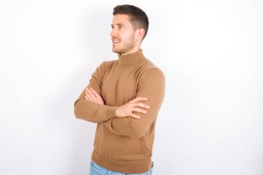 young caucasian man wearing turtleneck over white background cross hands look copy space