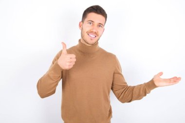 young caucasian man wearing turtleneck over white background Showing palm hand and doing ok gesture with thumbs up, smiling happy and cheerful.