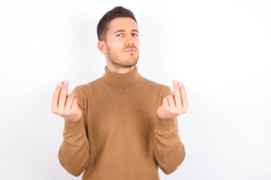 young caucasian man wearing turtleneck over white background doing money gesture with hands, asking for salary payment, millionaire business