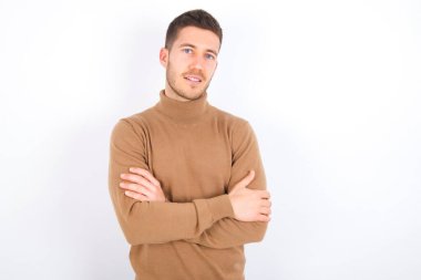 young caucasian man wearing turtleneck over white background happy face smiling with crossed arms looking at the camera. Positive person.