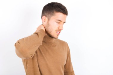 young caucasian man wearing turtleneck over white background Suffering of neck ache injury, touching neck with hand, muscular pain