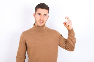young caucasian man wearing turtleneck over white background pointing up with fingers number nine in Chinese sign language Jiu