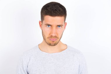 young caucasian man wearing casual clothes over white background depressed and worry for distress, crying angry and afraid. Sad expression.