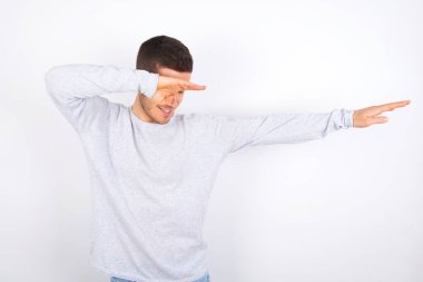 Photo of funky young caucasian man wearing casual clothes over white background show disco move dab