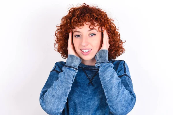 young caucasian woman red haired wearing blue T-shirt over white background Pleasant looking cheerful, Happy reaction
