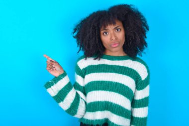 Mavi arka plan sırıtışları üzerine çizgili süveter giyen ciddi Afro-Amerikan kadın fotokopi alanındaki yüz hatları hoş olmayan bir şey gösteriyor. Şu reklama bak. Büyük fiyat konsepti
