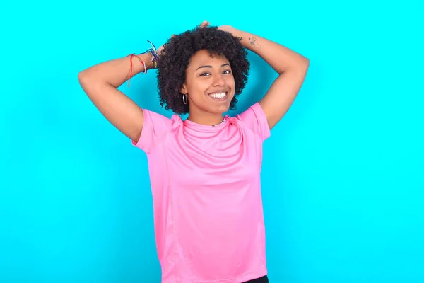 Młoda Afroamerykanka Ubrana Różowy Shirt Niebieskim Tle Rozciągające Się Ramiona — Zdjęcie stockowe