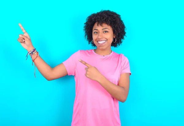 Młoda Afroamerykanka Ubrana Różowy Shirt Niebieskim Tle Wskazując Palcem Pustą — Zdjęcie stockowe