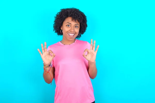 Młoda Afroamerykanka Ubrana Różowy Shirt Niebieskim Tle Pokazująca Obie Ręce — Zdjęcie stockowe