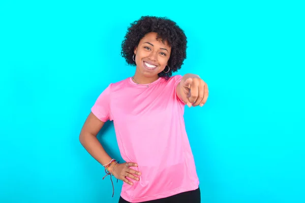 Młoda Afroamerykanka Ubrana Różowy Shirt Niebieskim Tle Wskazując Aparat Zadowolonym — Zdjęcie stockowe