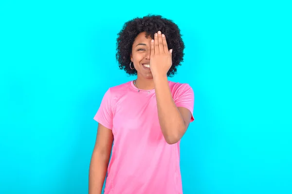 Young African American Woman Wearing Pink Shirt Blue Background Covering — Stockfoto