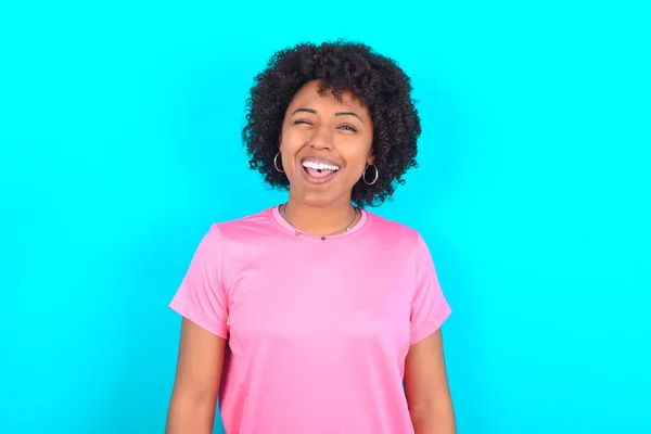 Jonge Afro Amerikaanse Vrouw Draagt Roze Shirt Blauwe Achtergrond Knipogen — Stockfoto