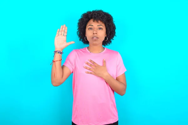 Młoda Afroamerykanka Ubrana Różowy Shirt Niebieskim Tle Przeklinając Dłonią Piersi — Zdjęcie stockowe