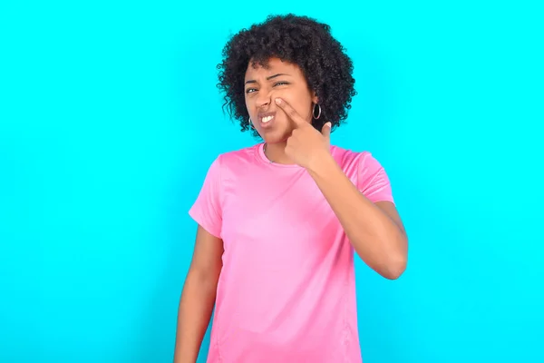 Young African American Woman Wearing Pink Shirt Blue Background Pointing — Stockfoto