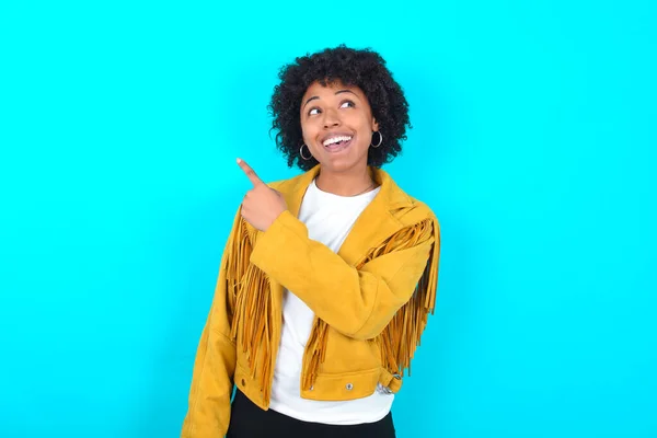 Młoda Afroamerykanka Ubrana Żółtą Kurtkę Frędzlową Nad Niebieskim Tłem Zadowolona — Zdjęcie stockowe