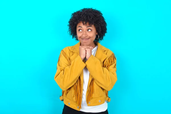 Ciekawa Młoda Afroamerykanka Ubrana Żółtą Frędzlową Kurtkę Niebieskim Tle Trzyma — Zdjęcie stockowe