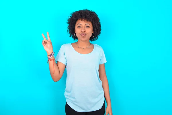 Afroamerykanka Afro Fryzury Noszenie Niebieskiej Koszulki Niebieskim Tle Sprawia Gest — Zdjęcie stockowe