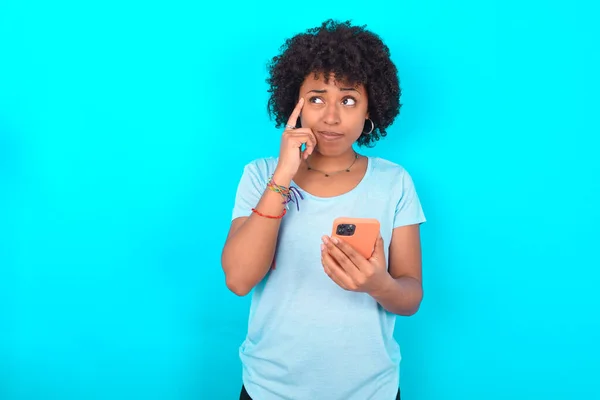 African American Woman Wearing Blue Shirt Blue Background Holding Gadget — Stockfoto