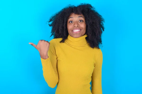 Mooie Afro Amerikaanse Vrouw Dragen Gele Coltrui Blauwe Achtergrond Wijzen — Stockfoto