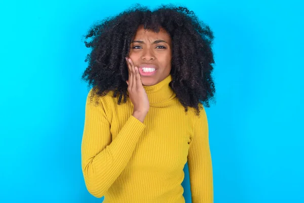 Afroamerykanka Żółtym Golfie Niebieskim Tle Dotykająca Ust Bolesnym Wyrazem Twarzy — Zdjęcie stockowe