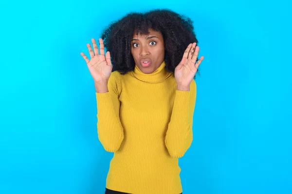 Afro Amerikaanse Vrouw Draagt Gele Coltrui Blauwe Achtergrond Handen Weghalen — Stockfoto