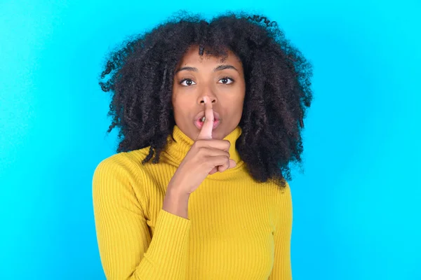 터틀넥을 배경을 아프리카 미국인 여성은 침묵의 몸짓을 입술에 손가락을 — 스톡 사진