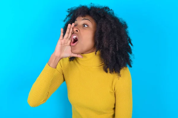 Afro Amerikaanse Vrouw Draagt Gele Coltrui Blauwe Achtergrond Schreeuwend Schreeuwend — Stockfoto