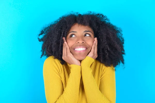 Geïnspireerde Afro Amerikaanse Vrouw Draagt Gele Coltrui Blauwe Achtergrond Kijkend — Stockfoto