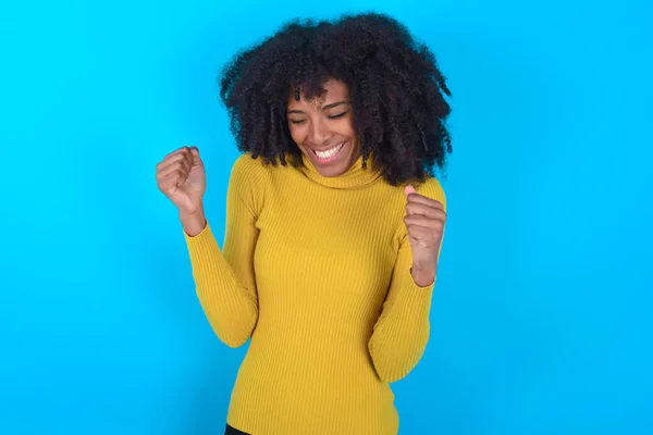 Afroamerykanka Żółtym Golfie Niebieskim Tle Bardzo Szczęśliwa Podekscytowana Wykonując Gest — Zdjęcie stockowe
