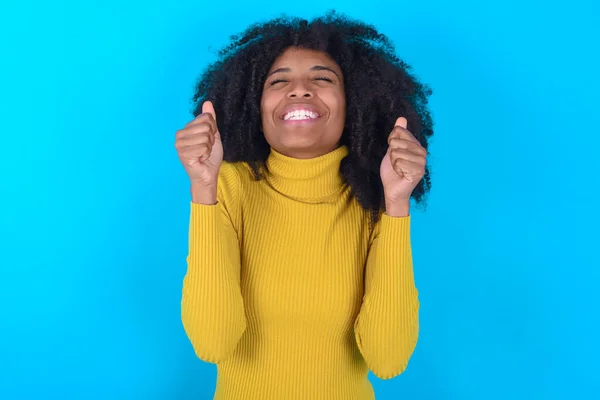 Afro Amerikaanse Vrouw Draagt Gele Coltrui Blauwe Achtergrond Wordt Opgewonden — Stockfoto