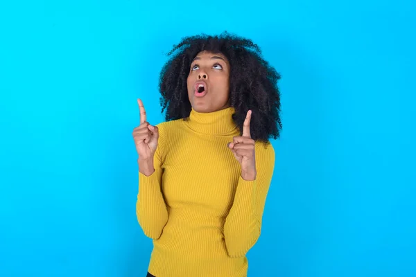 Afro Amerikaanse Vrouw Draagt Gele Coltrui Blauwe Achtergrond Verbaasd Verrast — Stockfoto