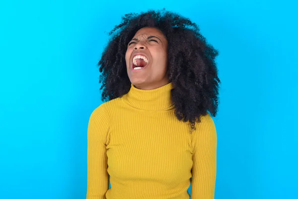 Afro Amerikaanse Vrouw Draagt Gele Coltrui Blauwe Achtergrond Boos Gek — Stockfoto