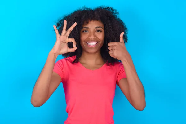 Afroamerykanka Ubrana Różowy Shirt Niebieskim Tle Uśmiecha Się Wygląda Szczęśliwie — Zdjęcie stockowe
