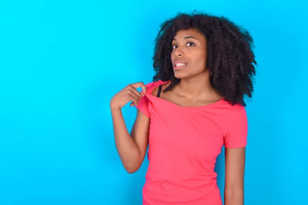 파란색 티셔츠를 아프리카 미국인 여성은 셔츠를 잡아당기는 문제가 것처럼 보이는 — 스톡 사진