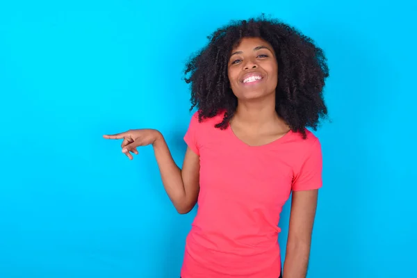 Afroamerykanka Ubrana Różowy Shirt Niebieskim Tle Śmieje Się Szczęśliwie Wskazując — Zdjęcie stockowe