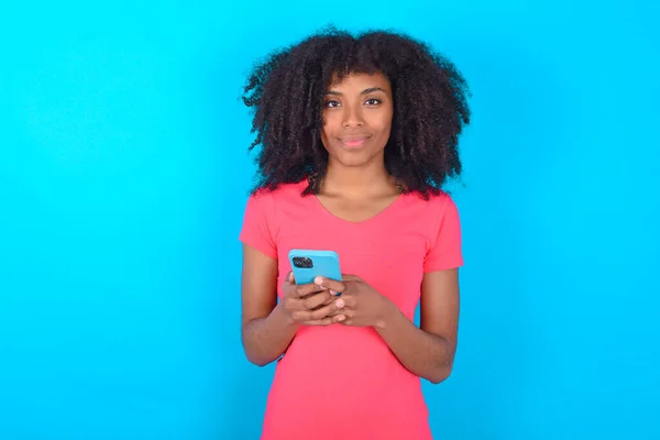 분홍색 티셔츠를 아프리카 미국인 복제품 공간을 휴대폰을 사용하고 Sms 메시지를 — 스톡 사진