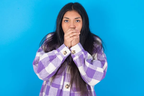 年轻的拉丁女人穿着格子呢衬衫披着蓝色的背景 站在外面感觉很冷 希望不会感冒 — 图库照片