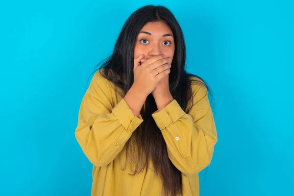 Stunned Young Latin Woman Wearing Yellow Shirt Blue Background Covers — ストック写真