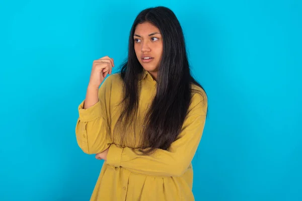 Astonished Young Latin Woman Wearing Yellow Shirt Blue Background Looks — Stok fotoğraf