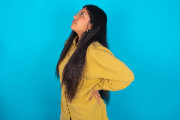 Joven Mujer Latina Vistiendo Camisa Amarilla Sobre Fondo Azul Tiene —  Fotos de Stock