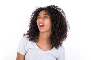 Young African American woman wearing grey T-shirt over white background yawns with opened mouth stands. Daily morning routine