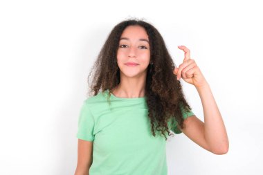 Afro saçlı genç kız yeşil arka planda beyaz tişört giyiyor. Çince işaret dilinde dokuz numara Jiu 'yu işaret ediyor.