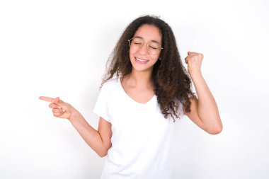 Afro saç stili, beyaz arka planda beyaz tişört giyen neşeli genç kız fotokopi alanı reklamını gösteriyor.