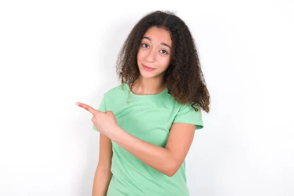 Teenager Girl Afro Hairstyle Wearing Green Shirt White Background Pointing — Stockfoto