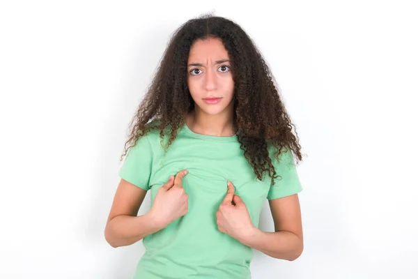Embarrassed Teenager Girl Afro Hairstyle Wearing White Shirt Green Background — Stockfoto